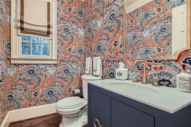 bathroom with wood-type flooring, vanity, toilet, and ornamental molding