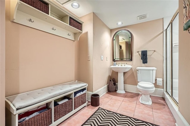 bathroom featuring tile patterned floors, sink, an enclosed shower, and toilet