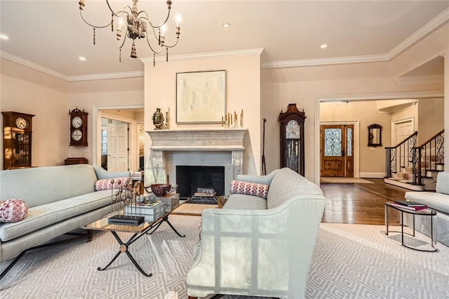 living room with a chandelier, light hardwood / wood-style floors, and crown molding