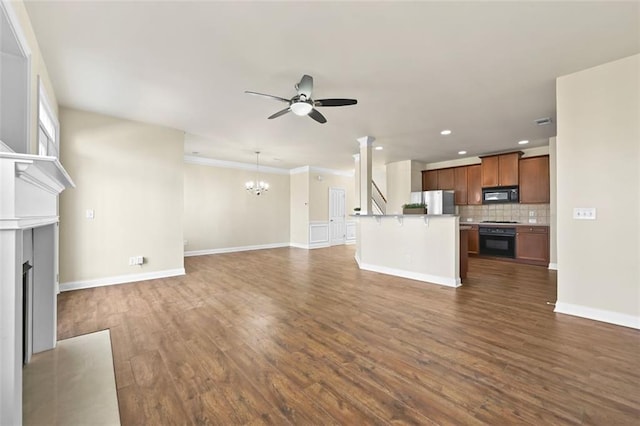 unfurnished living room with dark wood-style floors, a fireplace, baseboards, and ceiling fan with notable chandelier