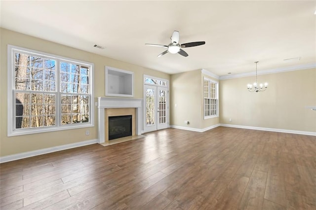 unfurnished living room featuring visible vents, baseboards, dark wood finished floors, a fireplace with flush hearth, and ceiling fan with notable chandelier