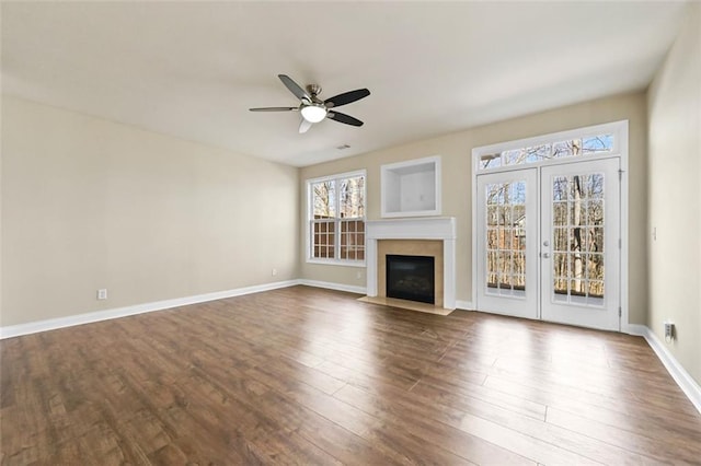 unfurnished living room with a ceiling fan, a fireplace with flush hearth, baseboards, and dark wood-type flooring