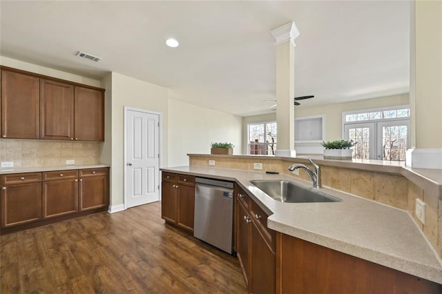 kitchen with a sink, visible vents, light countertops, decorative backsplash, and dishwasher