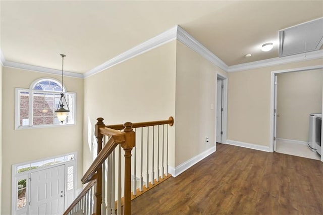 hallway featuring attic access, baseboards, crown molding, and an upstairs landing