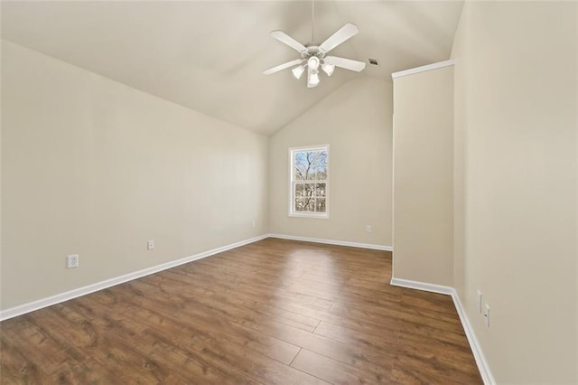 empty room featuring a ceiling fan, dark wood-style flooring, vaulted ceiling, and baseboards