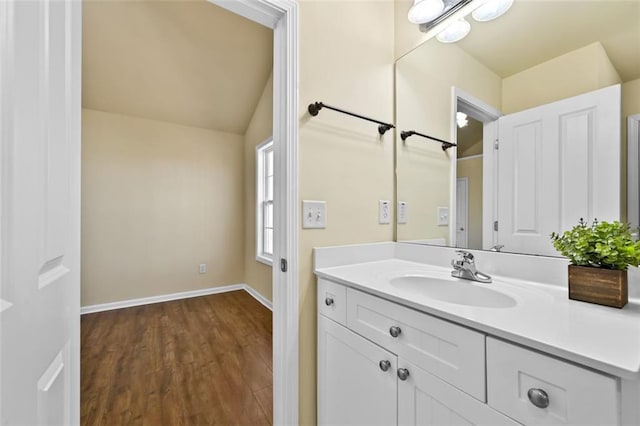 bathroom featuring baseboards, wood finished floors, and vanity