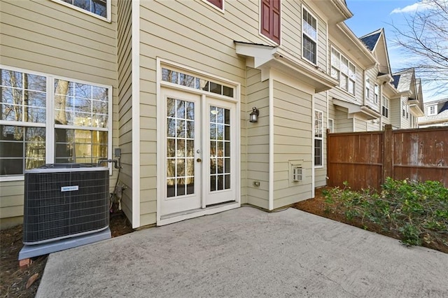 doorway to property with a patio, french doors, fence, and central air condition unit