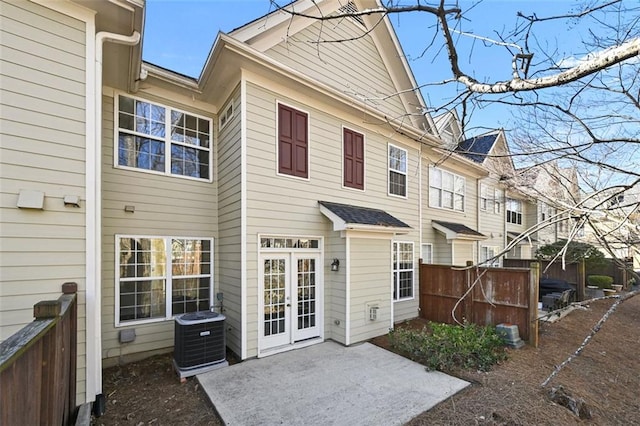 rear view of property featuring central AC unit, a patio area, and fence