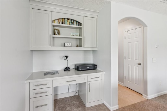 1671 Bismarck Cir, Winder, GA 30680 - home office with arched walkways, light carpet, baseboards, and light tile patterned floors