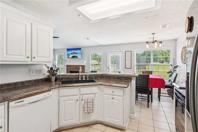1671 Bismarck Cir, Winder, GA 30680 - kitchen with white dishwasher, a sink, plenty of natural light, a fireplace, and a textured ceiling
