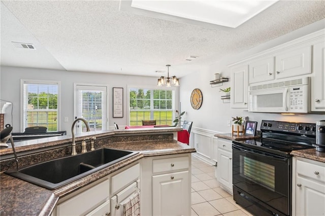 1671 Bismarck Cir, Winder, GA 30680 - kitchen featuring white microwave, black electric range, a sink, dark countertops, and a chandelier