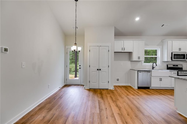 kitchen with appliances with stainless steel finishes, light wood-type flooring, white cabinetry, a chandelier, and recessed lighting