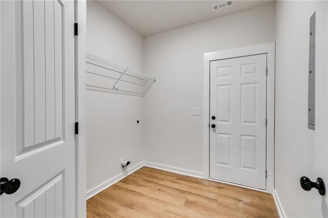 washroom with electric dryer hookup, light wood-style floors, and baseboards
