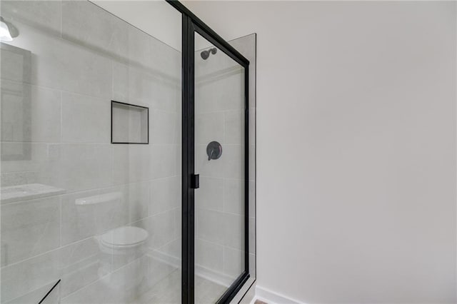 full bath featuring a stall shower and toilet