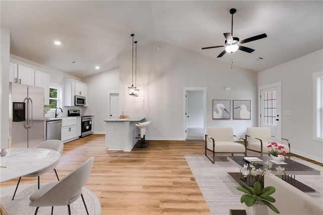 living room featuring light wood finished floors, ceiling fan, high vaulted ceiling, baseboards, and recessed lighting