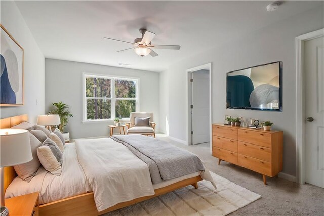 unfurnished bedroom featuring light carpet, ceiling fan, and ensuite bathroom