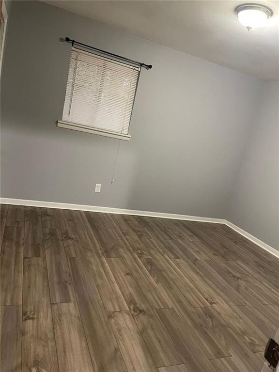 unfurnished room with baseboards and wood finished floors