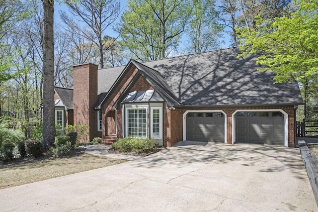2689 Spring Rock Ct NE, Roswell, GA 30075 - tudor home featuring an attached garage, concrete driveway, a chimney, and brick siding