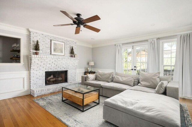 2689 Spring Rock Ct NE, Roswell, GA 30075 - living room with wood finished floors, ceiling fan, ornamental molding, a fireplace, and wainscoting