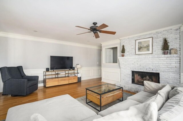 2689 Spring Rock Ct NE, Roswell, GA 30075 - living room with ceiling fan, wood finished floors, crown molding, a wainscoted wall, and a brick fireplace