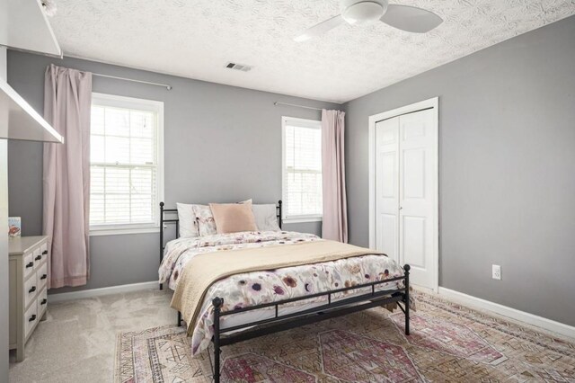 2689 Spring Rock Ct NE, Roswell, GA 30075 - bedroom featuring light colored carpet, ceiling fan, a closet, and a textured ceiling