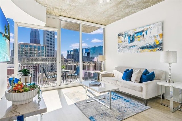 living area with a view of city, expansive windows, and wood finished floors