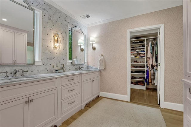 bathroom featuring vanity, hardwood / wood-style flooring, and ornamental molding