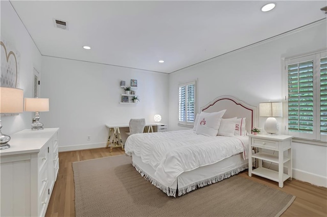 bedroom featuring multiple windows and light hardwood / wood-style floors