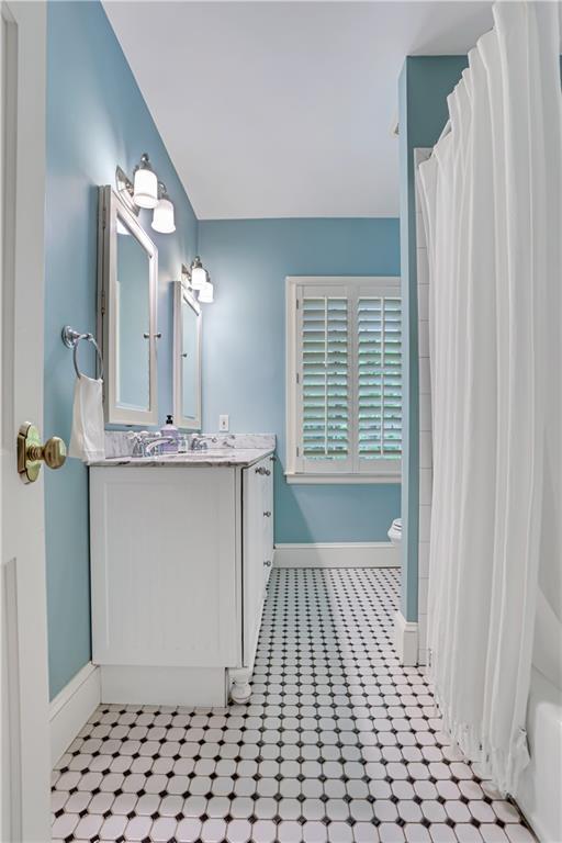 bathroom featuring vanity, curtained shower, and toilet