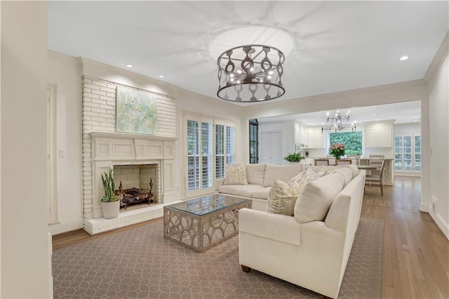 living room featuring hardwood / wood-style flooring, a notable chandelier, and a fireplace