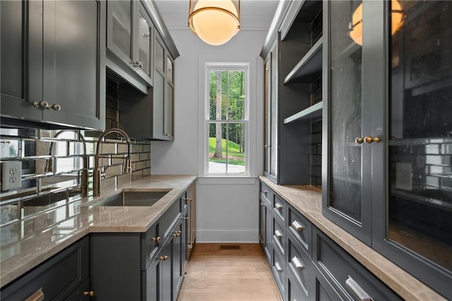 384 Hickory Pass, Alpharetta, GA 30004 - kitchen with a sink, baseboards, light wood-style floors, decorative backsplash, and light stone countertops