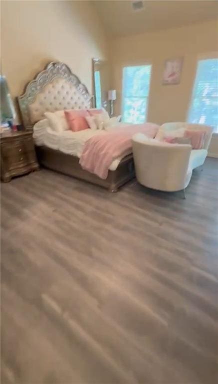 bedroom with wood finished floors and vaulted ceiling