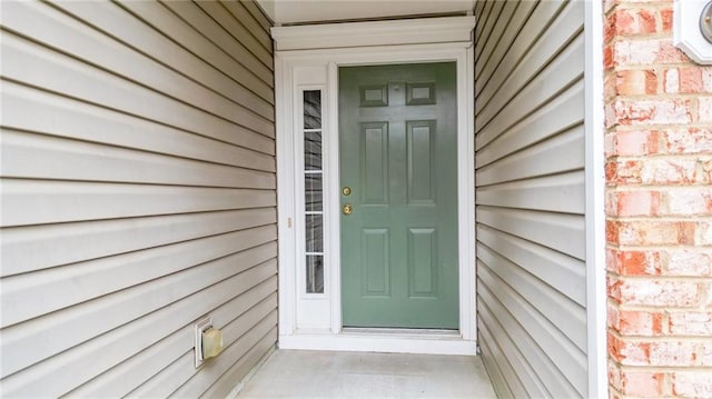 property entrance featuring brick siding