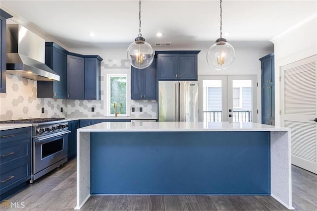 kitchen featuring a center island, hardwood / wood-style floors, wall chimney exhaust hood, and premium appliances