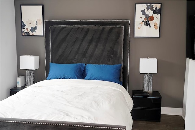 bedroom with wood finished floors and baseboards