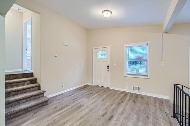 entrance foyer featuring lofted ceiling and light hardwood / wood-style flooring