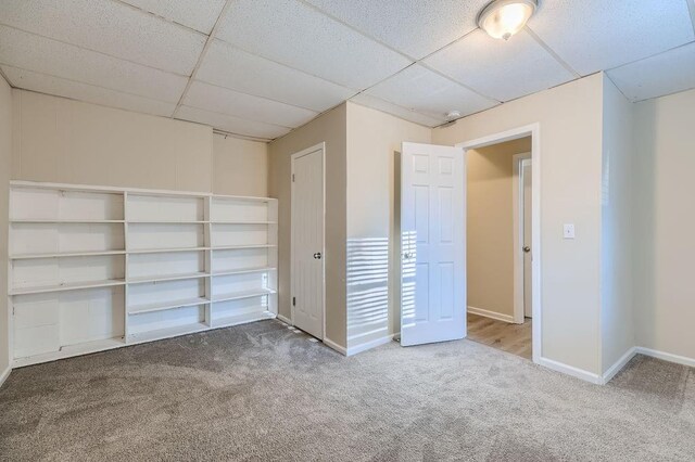 interior space featuring carpet floors and a drop ceiling