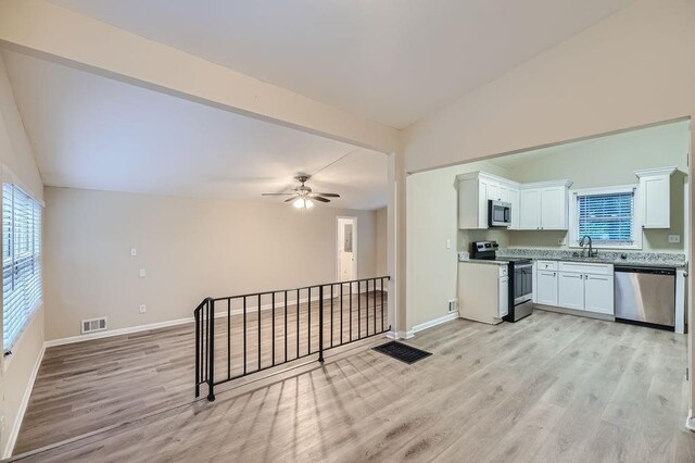 interior space featuring vaulted ceiling, sink, ceiling fan, and light hardwood / wood-style floors