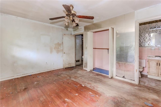 unfurnished bedroom with wood-type flooring and ensuite bath