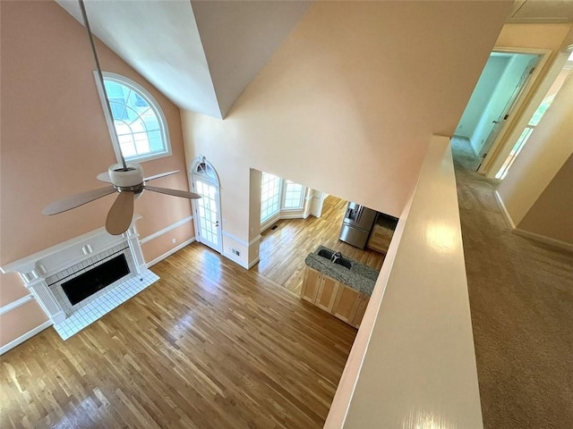 4770 Powers Park Ct NE, Marietta, GA 30067 - unfurnished living room with a ceiling fan, baseboards, wood finished floors, a fireplace, and high vaulted ceiling