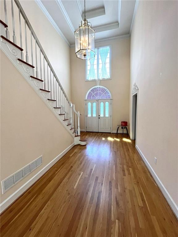 4770 Powers Park Ct NE, Marietta, GA 30067 - entrance foyer with a chandelier, stairs, wood finished floors, baseboards, and a high ceiling
