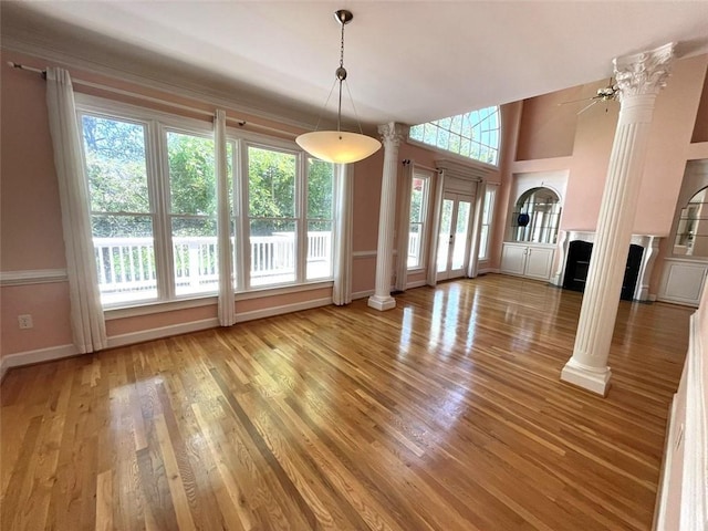 4770 Powers Park Ct NE, Marietta, GA 30067 - unfurnished living room with ornate columns, a fireplace, wood finished floors, and baseboards