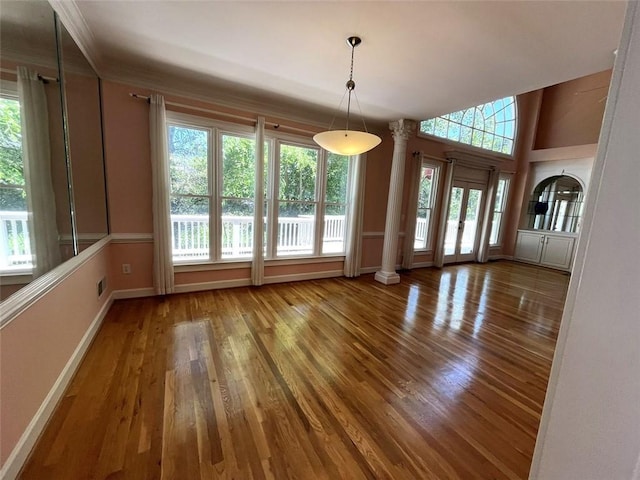 4770 Powers Park Ct NE, Marietta, GA 30067 - unfurnished dining area with wood finished floors, baseboards, ornate columns, and ornamental molding