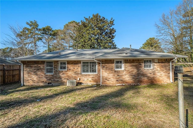 rear view of property featuring cooling unit and a yard