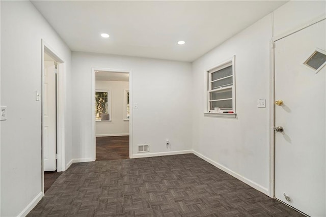 unfurnished room featuring dark parquet flooring