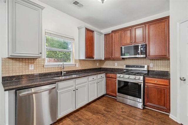 4515 Ambassador Way, Cumming, GA 30040 - kitchen featuring stainless steel appliances, a sink, dark wood-type flooring, backsplash, and dark stone countertops
