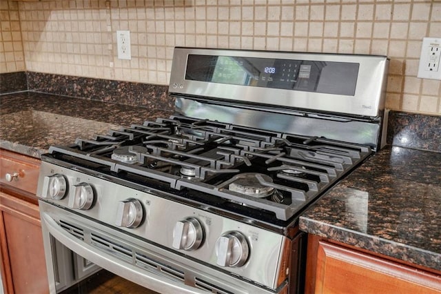 4515 Ambassador Way, Cumming, GA 30040 - kitchen view of stainless steel range with gas cooktop, backsplash, and brown cabinetry