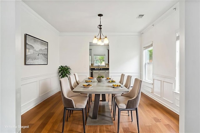 4515 Ambassador Way, Cumming, GA 30040 - dining space featuring plenty of natural light, wood finished floors, a decorative wall, crown molding, and a wainscoted wall