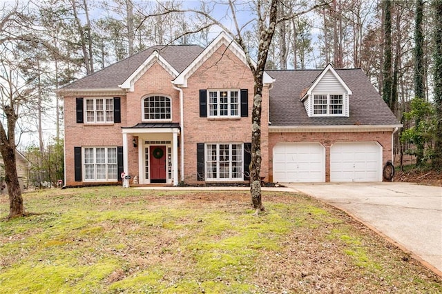 view of front facade featuring driveway, a garage, a front yard, and brick siding