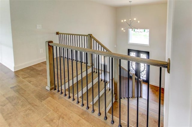 3065 Reserve Ct SW, Conyers, GA 30094 - stairs with a chandelier, wood finished floors, baseboards, and a high ceiling